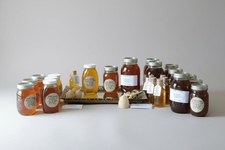 Jars of honey with labels on a white surface